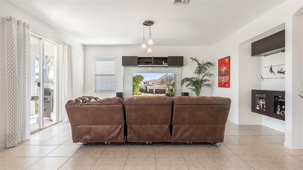 19470 Stonebrook Street Weston, FL 33332 - Photo 9 of 44 a living room with furniture a fireplace and a flat screen tv