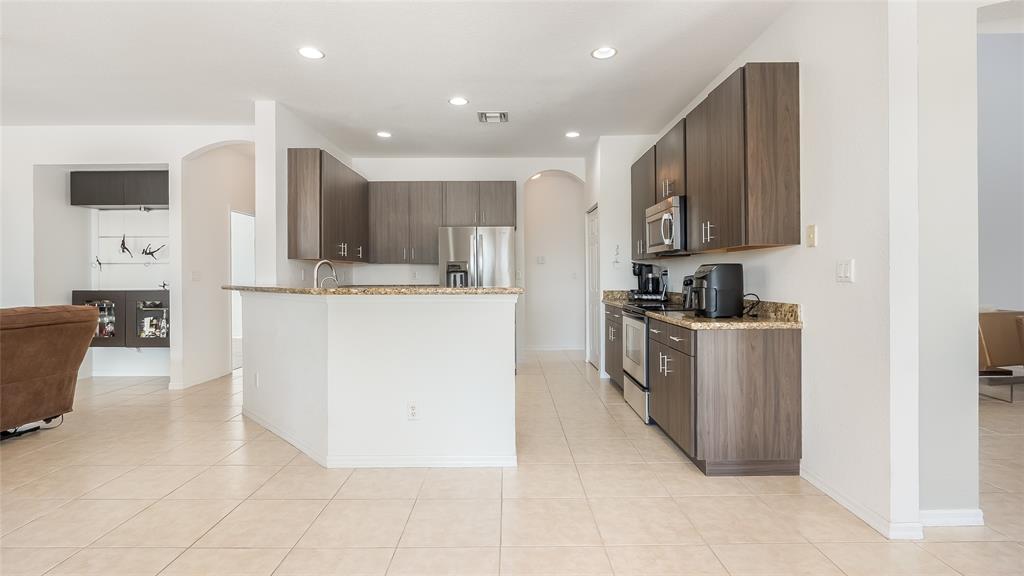 19470 Stonebrook Street Weston, FL 33332 - Photo 10 of 44 a kitchen with kitchen island cabinets and refrigerator