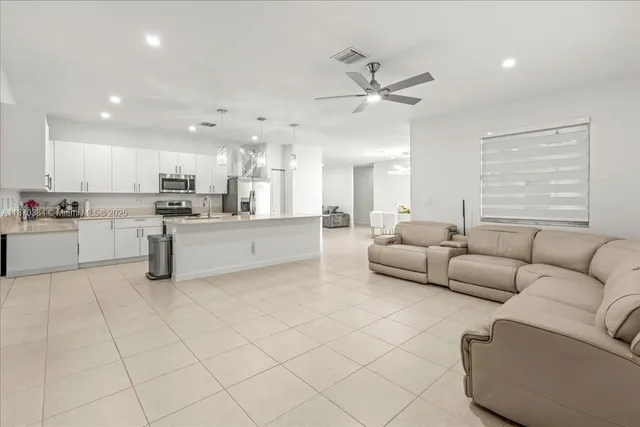 a living room with furniture and kitchen view