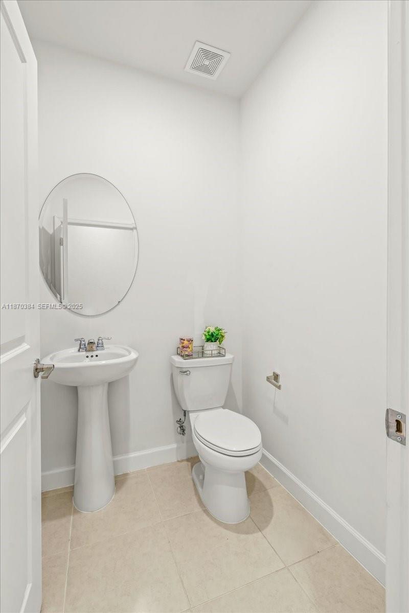 19803 Southwest 321st Street Homestead, FL 33030 - Photo 21 of 48 a bathroom with a sink a toilet and mirror