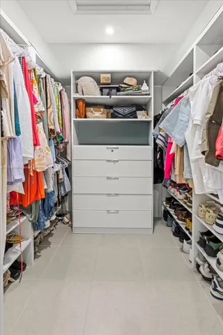 a view of walk in closet with clothes and shoes