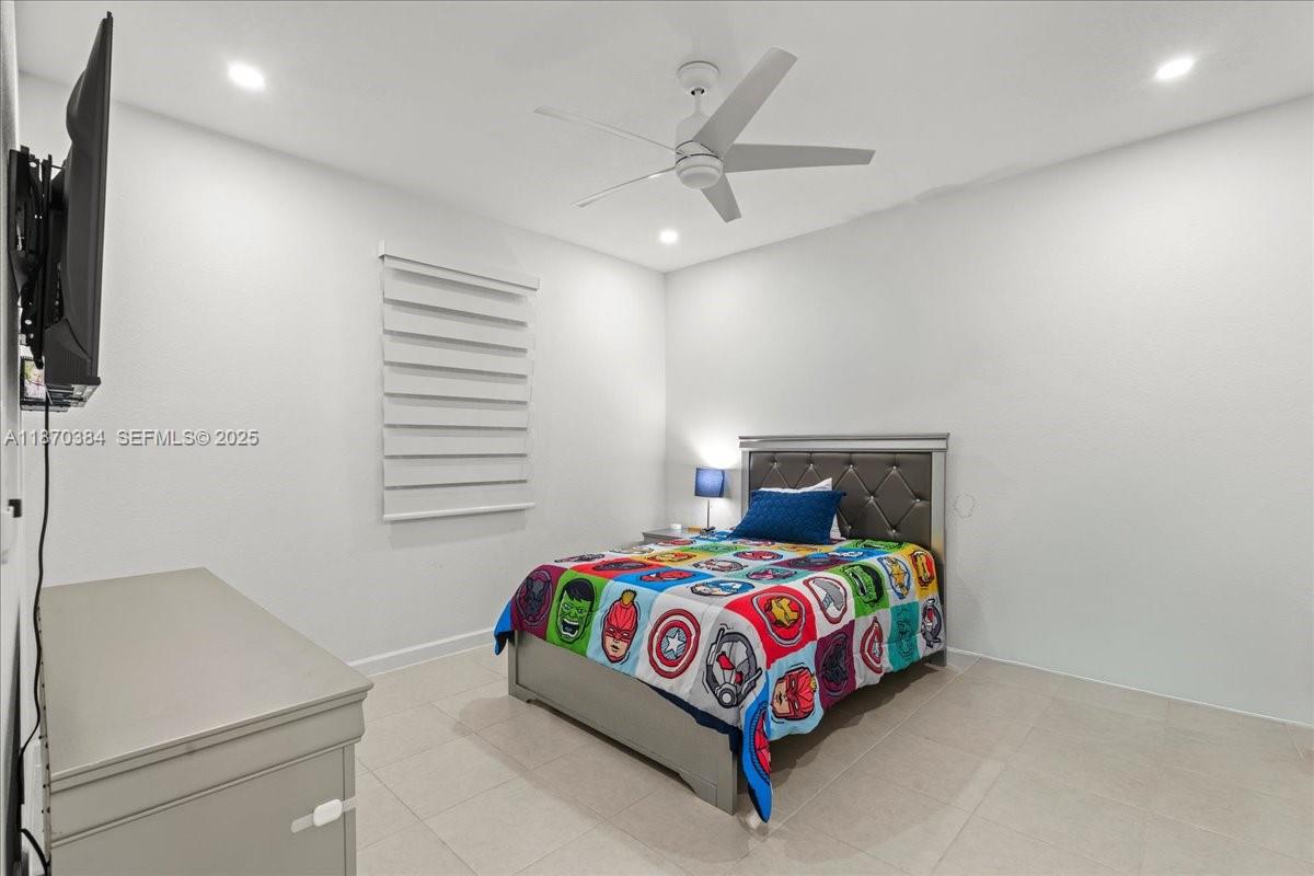 19803 Southwest 321st Street Homestead, FL 33030 - Photo 33 of 48 a bedroom with a bed and a ceiling fan