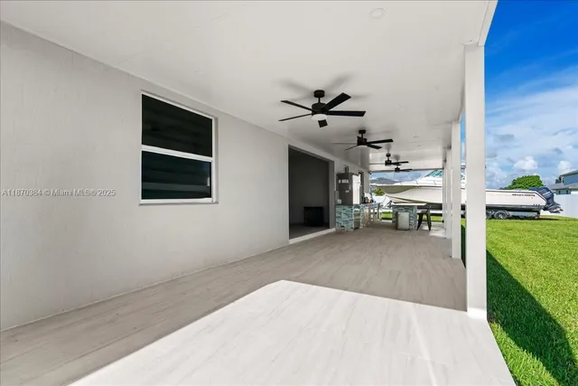 a kitchen with stainless steel appliances granite countertop a stove and a view of living room