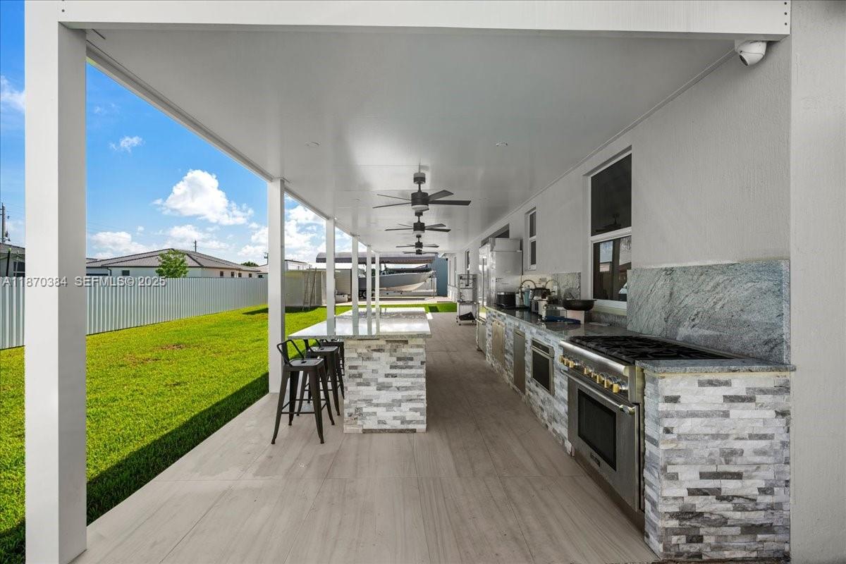 19803 Southwest 321st Street Homestead, FL 33030 - Photo 42 of 48 a kitchen with stainless steel appliances granite countertop a stove and a view of living room