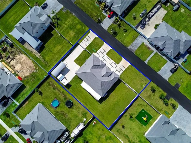 an aerial view of a tennis ground and a cars park