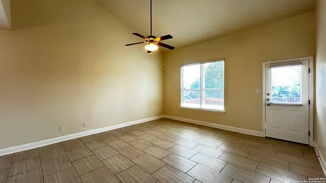 an empty room with windows and fan