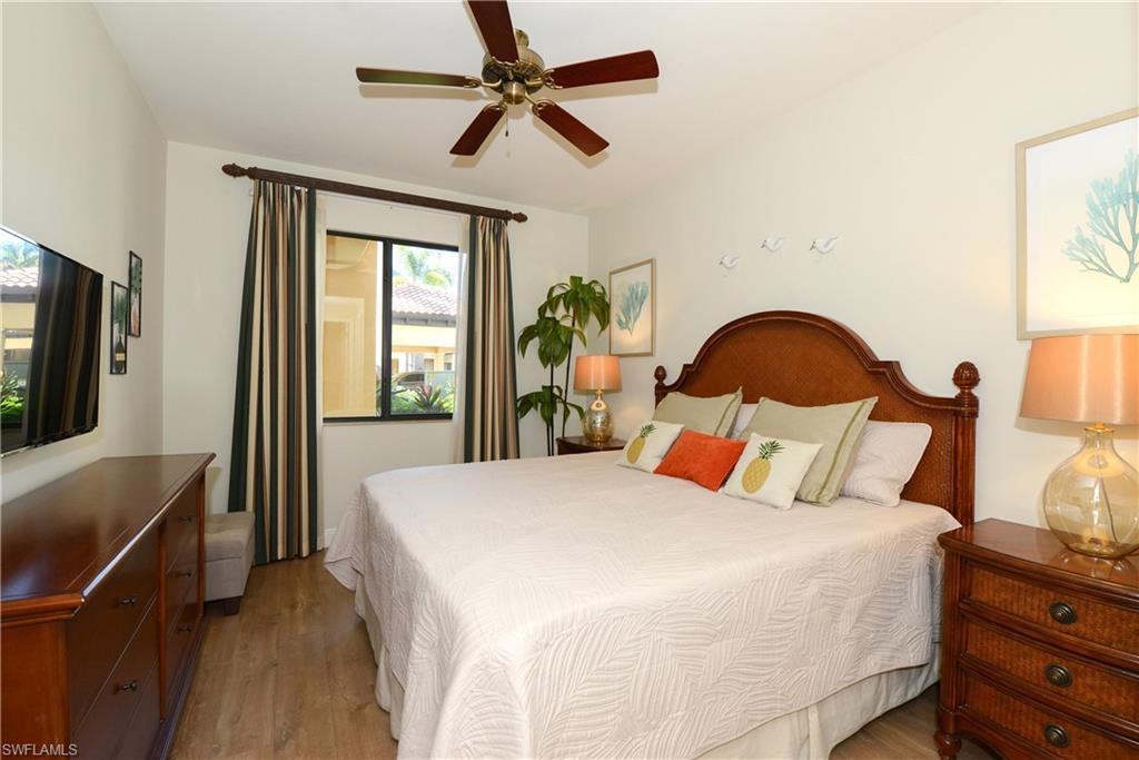 975 Sandpiper Street, Unit A104 Naples, FL 34102 - Photo 12 of 33 a bedroom with a bed a dresser next to a window with the outer view
