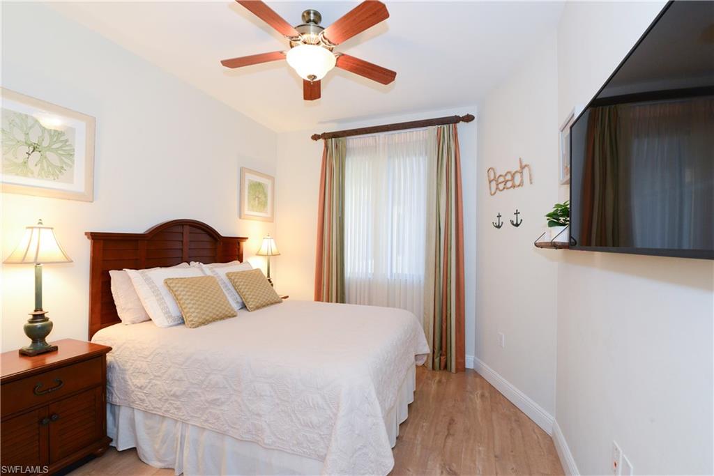 975 Sandpiper Street, Unit A104 Naples, FL 34102 - Photo 14 of 33 a bedroom with a bed and a painting on the wall