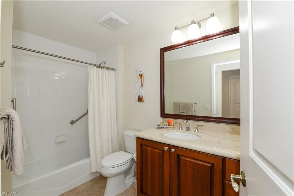 975 Sandpiper Street, Unit A104 Naples, FL 34102 - Photo 15 of 33 a bathroom with a granite countertop sink toilet and shower