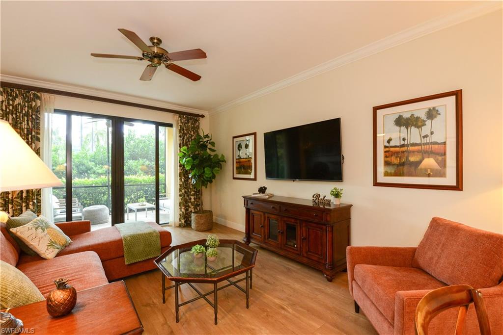 975 Sandpiper Street, Unit A104 Naples, FL 34102 - Photo 4 of 33 a living room with furniture and a flat screen tv