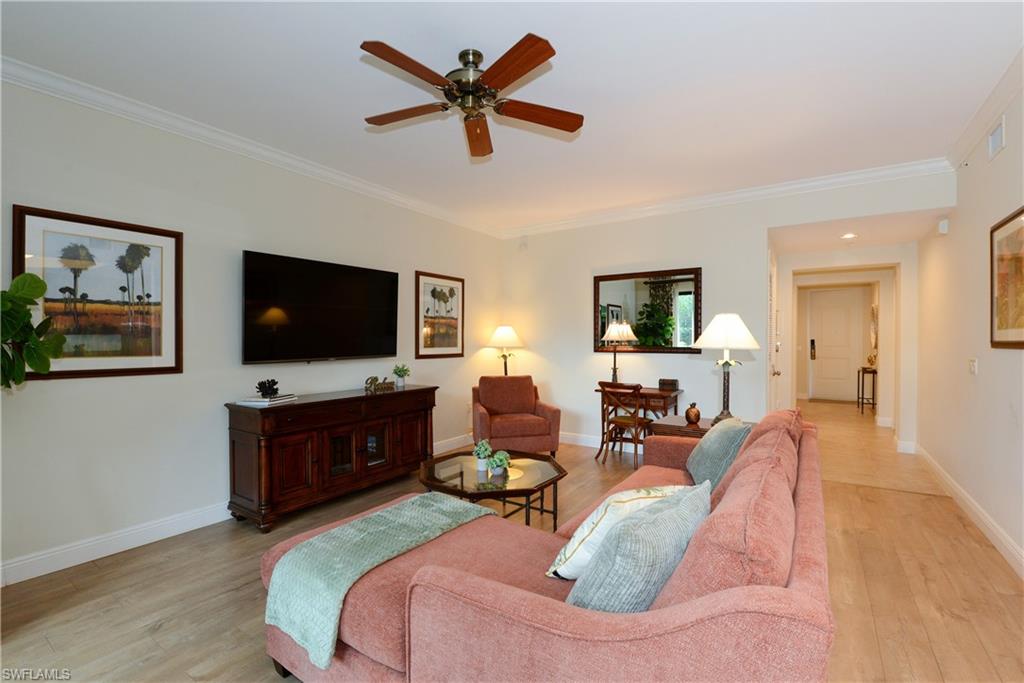 975 Sandpiper Street, Unit A104 Naples, FL 34102 - Photo 5 of 33 a living room with furniture and a flat screen tv