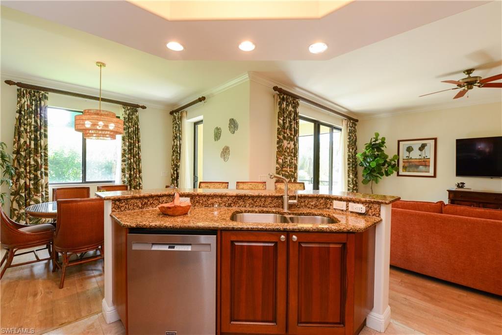 975 Sandpiper Street, Unit A104 Naples, FL 34102 - Photo 6 of 33 a kitchen with stainless steel appliances granite countertop a sink a stove and a refrigerator