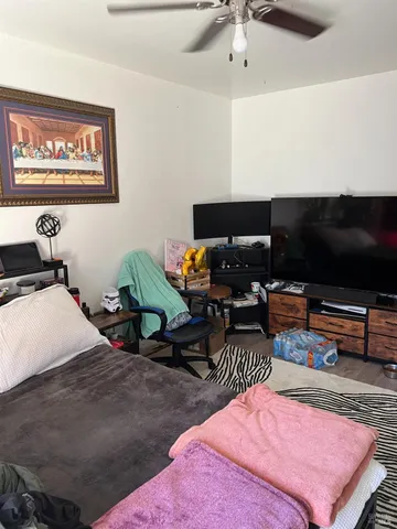 a bedroom with furniture and a flat screen tv
