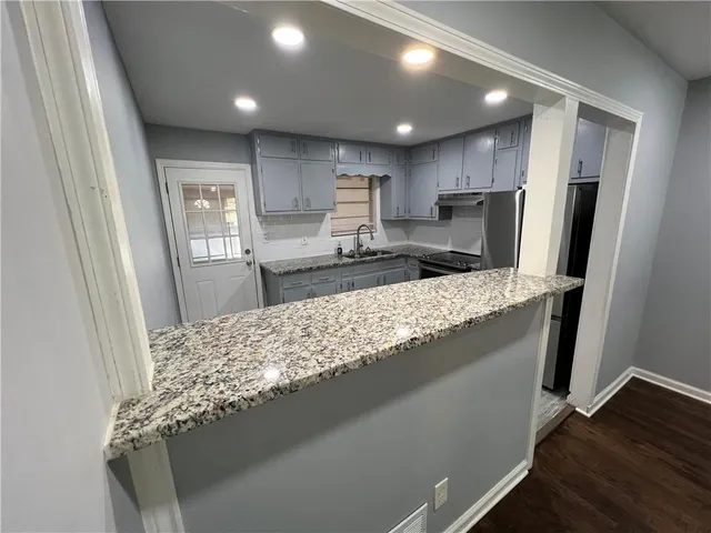 a kitchen with stainless steel appliances granite countertop a refrigerator sink and stove