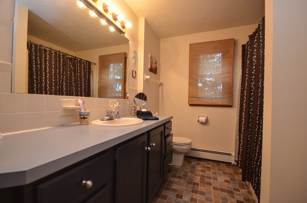 66 Dodge Hill Road Sutton, MA 01590 - Photo 14 of 29 a bathroom with a sink a toilet a mirror and shower