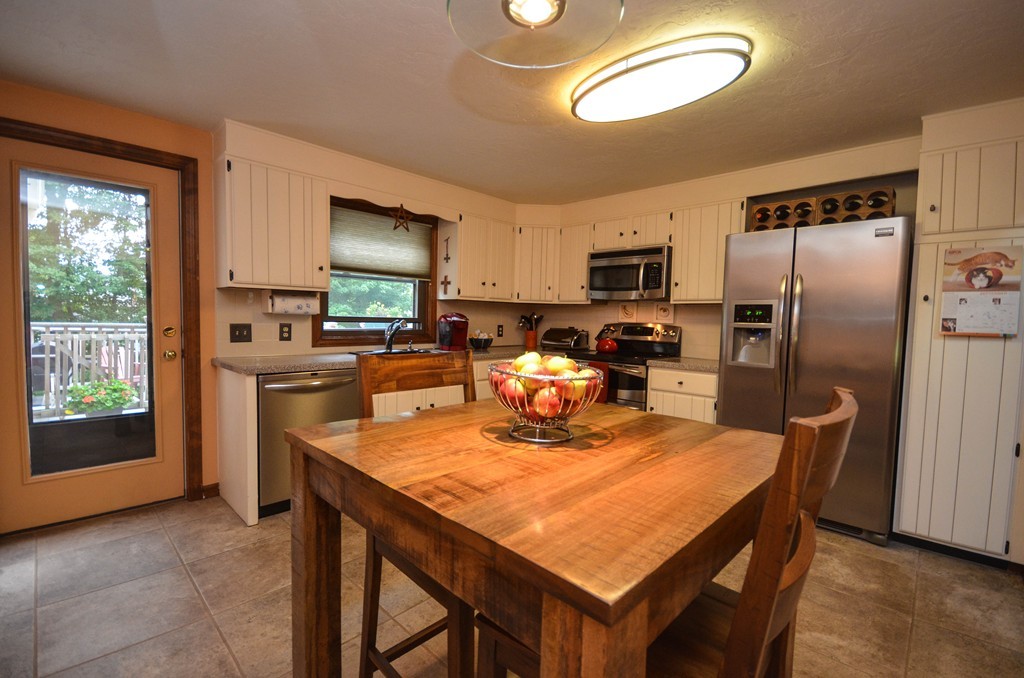 66 Dodge Hill Road Sutton, MA 01590 - Photo 8 of 29 a kitchen with a table chairs refrigerator and microwave