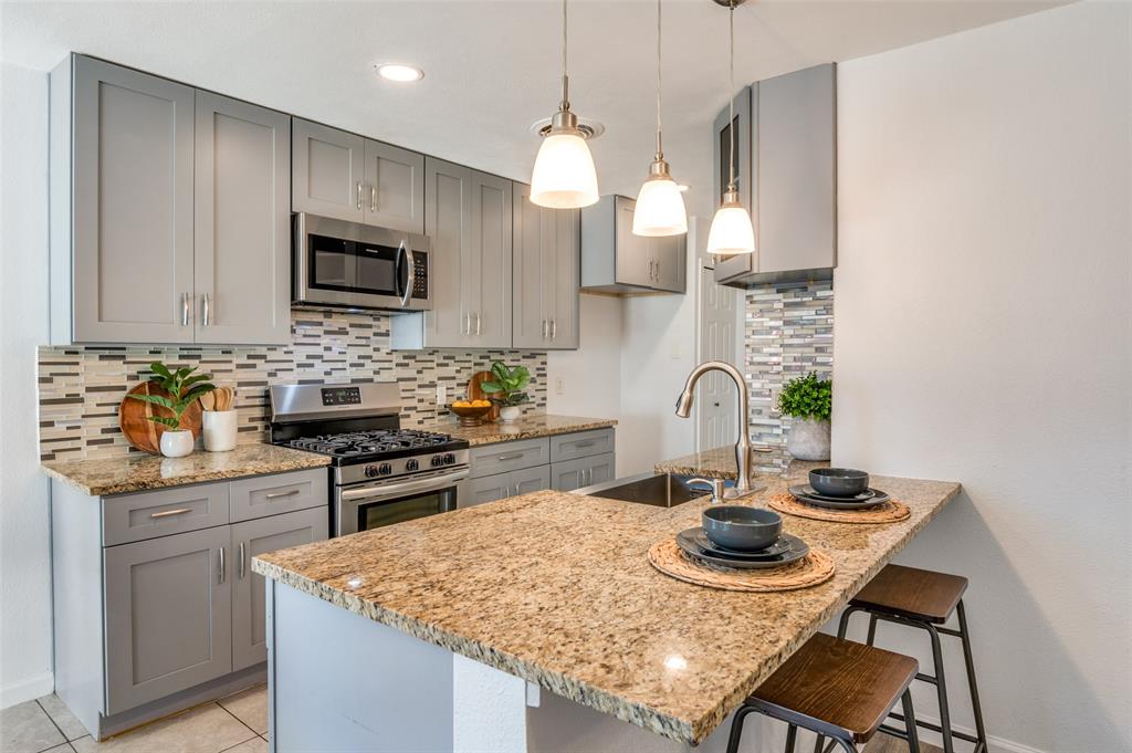 1209 Ridgeway Drive Richardson, TX 75080 - Photo 12 of 33 a kitchen with kitchen island a stove and a sink with granite countertops