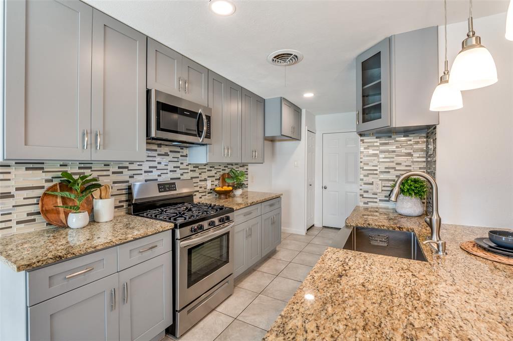 1209 Ridgeway Drive Richardson, TX 75080 - Photo 13 of 33 a kitchen with stainless steel appliances granite countertop a stove top oven a sink a counter space and cabinets