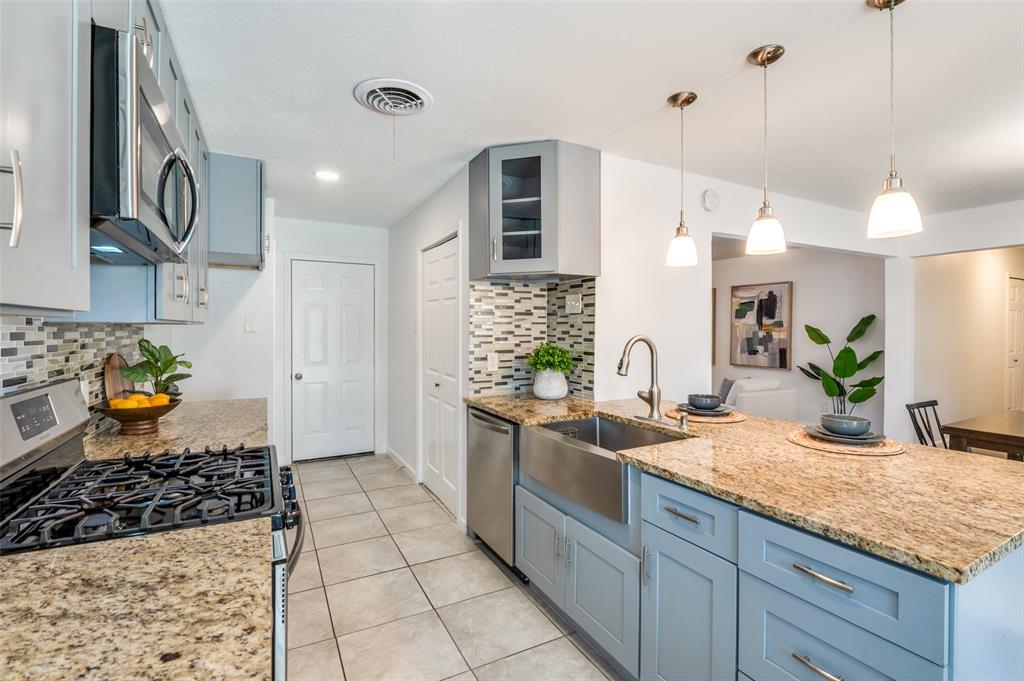1209 Ridgeway Drive Richardson, TX 75080 - Photo 14 of 33 a kitchen with stainless steel appliances granite countertop a sink stove and cabinets