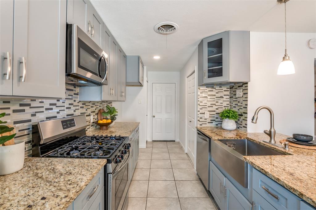 1209 Ridgeway Drive Richardson, TX 75080 - Photo 15 of 33 a kitchen with stainless steel appliances granite countertop a sink stove and refrigerator