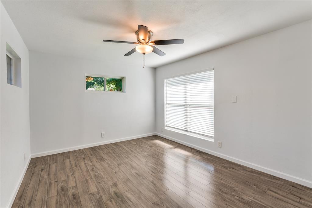 1209 Ridgeway Drive Richardson, TX 75080 - Photo 22 of 33 an empty room with wooden floor fan and windows