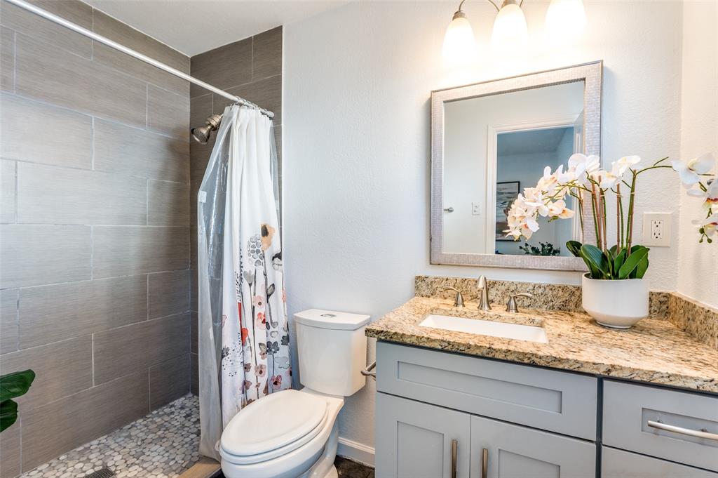 1209 Ridgeway Drive Richardson, TX 75080 - Photo 25 of 33 a bathroom with a granite countertop sink a toilet and shower