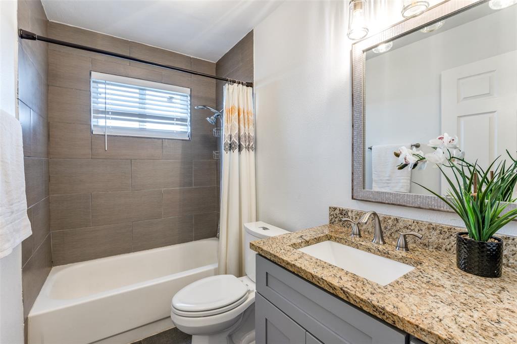 1209 Ridgeway Drive Richardson, TX 75080 - Photo 29 of 33 a bathroom with a granite countertop sink toilet and shower