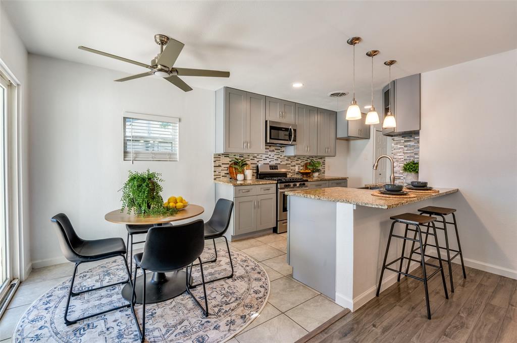 1209 Ridgeway Drive Richardson, TX 75080 - Photo 10 of 33 a kitchen with kitchen island white cabinets and stainless steel appliances