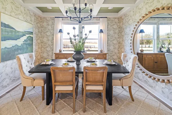a kitchen with stainless steel appliances granite countertop a stove a refrigerator a microwave a dining table and chairs with wooden floor