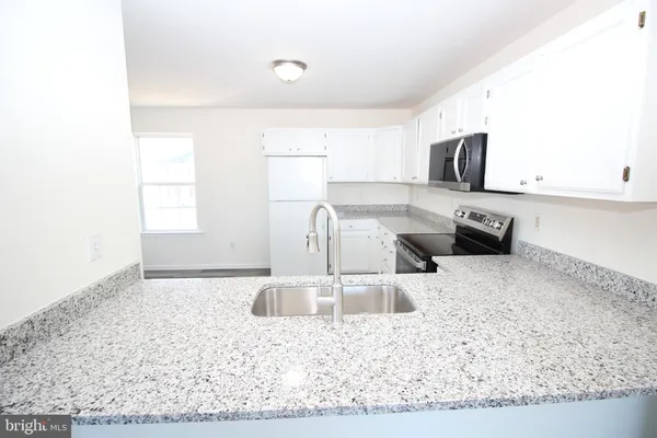 a kitchen with stainless steel appliances granite countertop a sink a stove and a microwave