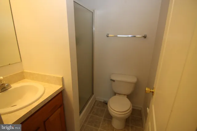 a bathroom with a granite countertop toilet and a sink