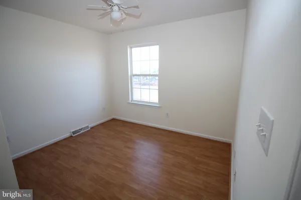 an empty room with a window and a fan