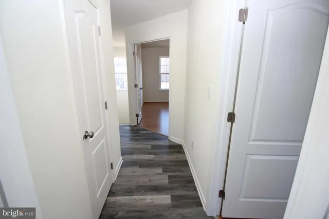 a view of a hallway with wooden floor and entryway