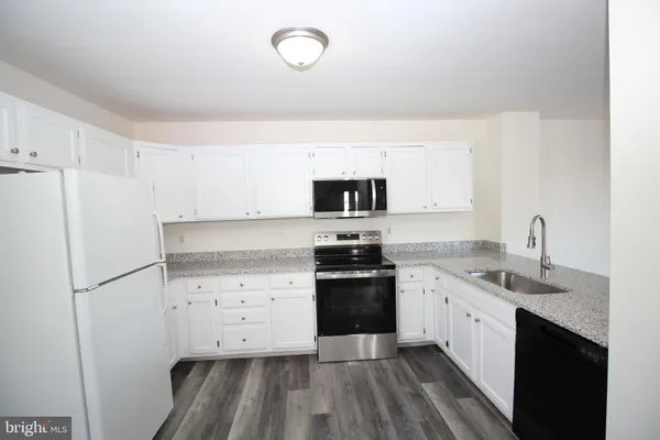 a kitchen with a sink stove and refrigerator