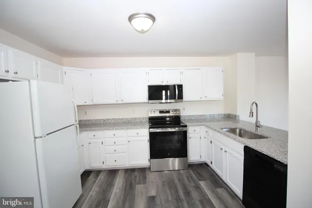 a kitchen with a sink stove and refrigerator