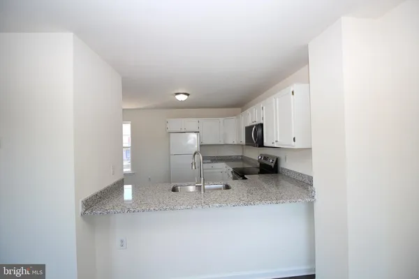 a kitchen with stainless steel appliances granite countertop a sink and cabinets