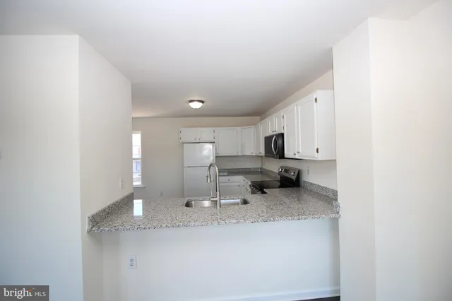 a kitchen with stainless steel appliances granite countertop a sink and cabinets