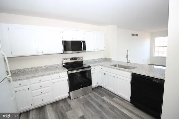 a kitchen with appliances cabinets and a sink