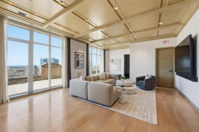 a living room with couches a coffee table and a potted plant