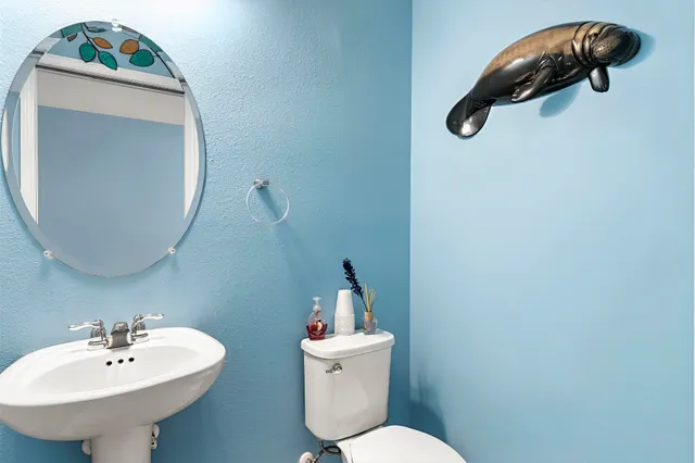 a bathroom with a toilet sink and mirror