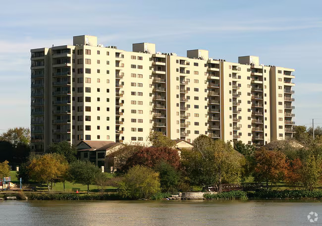 a front view of a building with lake view and plants
