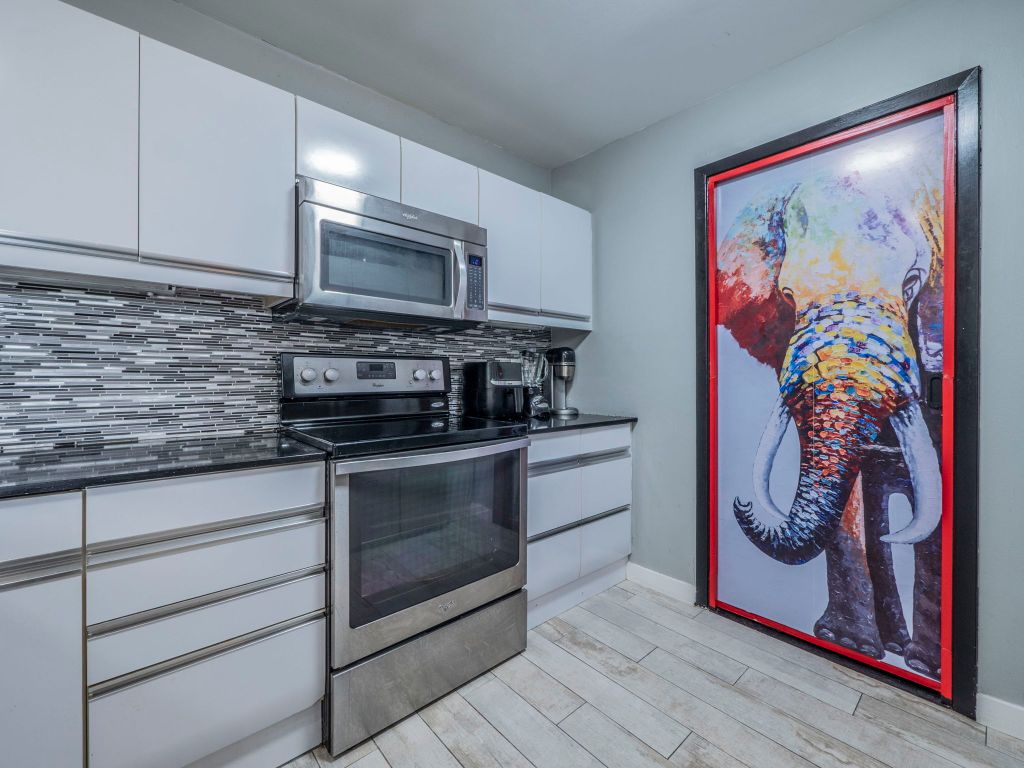 40 North Interstate Highway 35, Unit 4A4 Austin, TX 78701 - Photo 10 of 40 a kitchen with stainless steel appliances granite countertop a stove a sink and a microwave