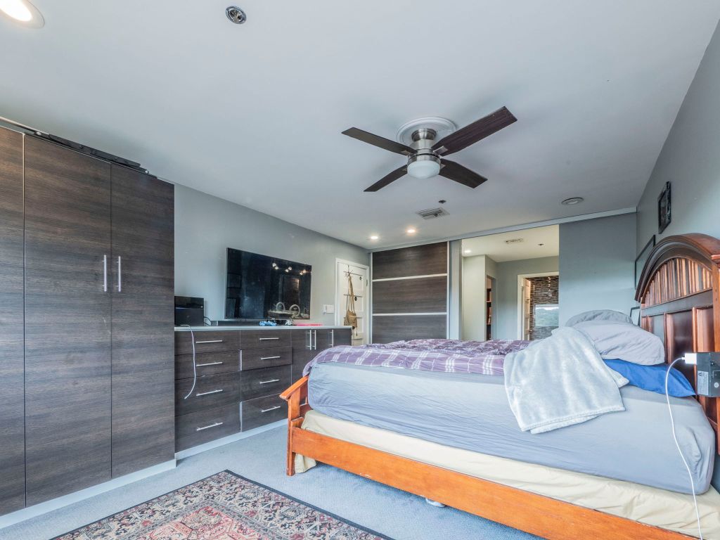 40 North Interstate Highway 35, Unit 4A4 Austin, TX 78701 - Photo 12 of 40 a bedroom with a large bed a flat tv screen and a dresser