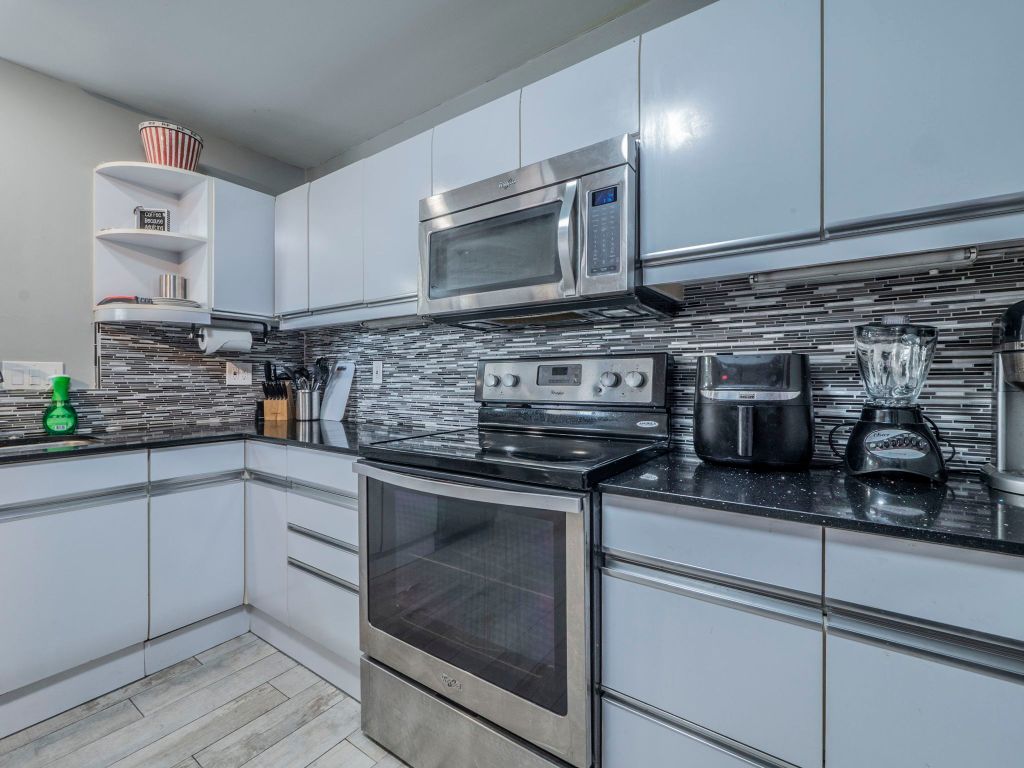 40 North Interstate Highway 35, Unit 4A4 Austin, TX 78701 - Photo 8 of 40 a kitchen with stainless steel appliances granite countertop a stove and a microwave