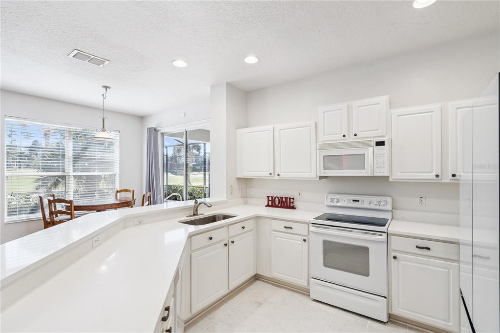3823 Beacon Ridge Way Clermont, FL 34711 - Photo 16 of 57 a kitchen with white cabinets sink and white appliances