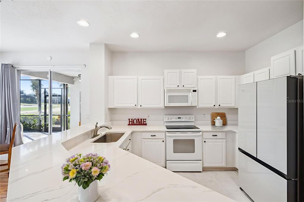 3823 Beacon Ridge Way Clermont, FL 34711 - Photo 17 of 57 a kitchen with white cabinets and white appliances