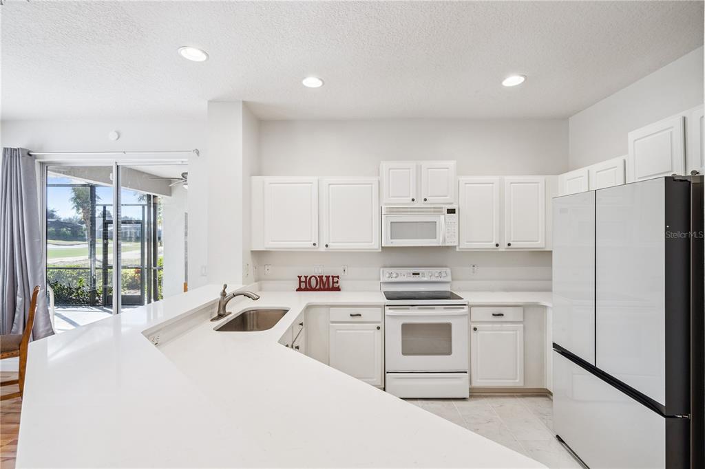 3823 Beacon Ridge Way Clermont, FL 34711 - Photo 18 of 57 a kitchen that has a lot of white cabinets and stainless steel appliances