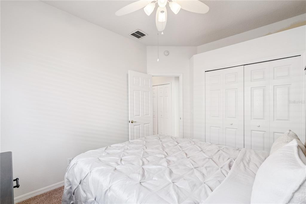 3823 Beacon Ridge Way Clermont, FL 34711 - Photo 22 of 57 a view of a bedroom with a bed and a chandelier fan