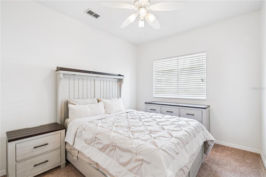 3823 Beacon Ridge Way Clermont, FL 34711 - Photo 23 of 57 a bedroom with a large bed and a chandelier