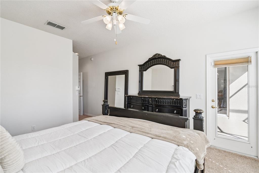 3823 Beacon Ridge Way Clermont, FL 34711 - Photo 29 of 57 a bedroom with a bed and a chandelier